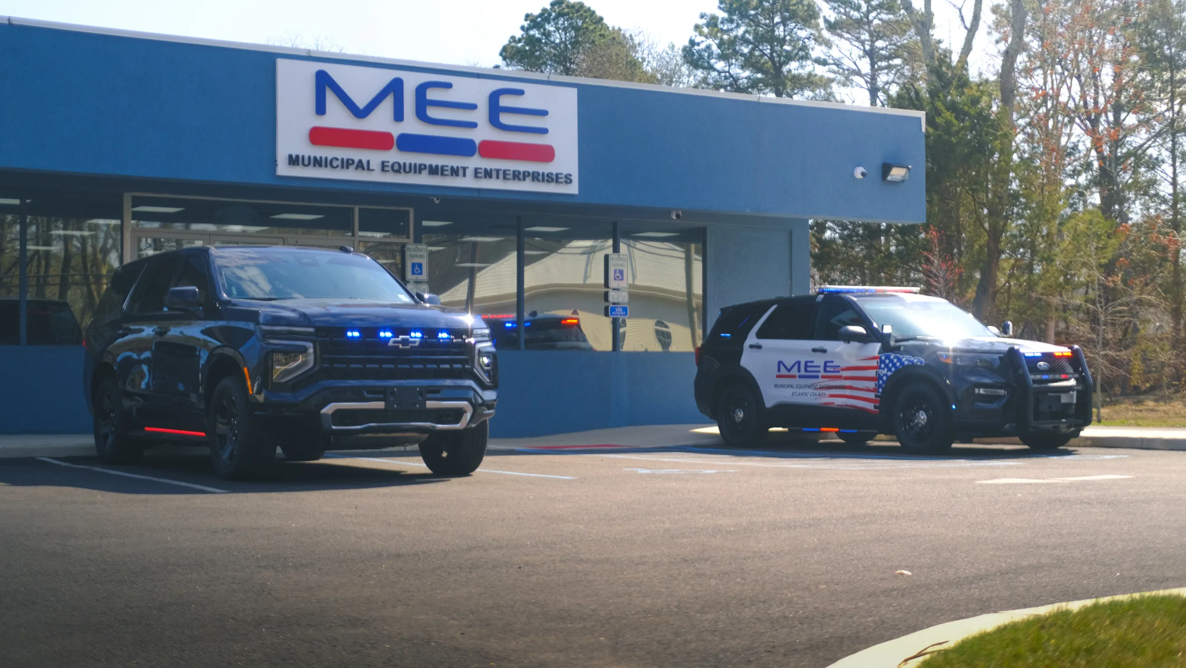 MEE vehicles with warning lights outside Municipal Equipment Enterprises
