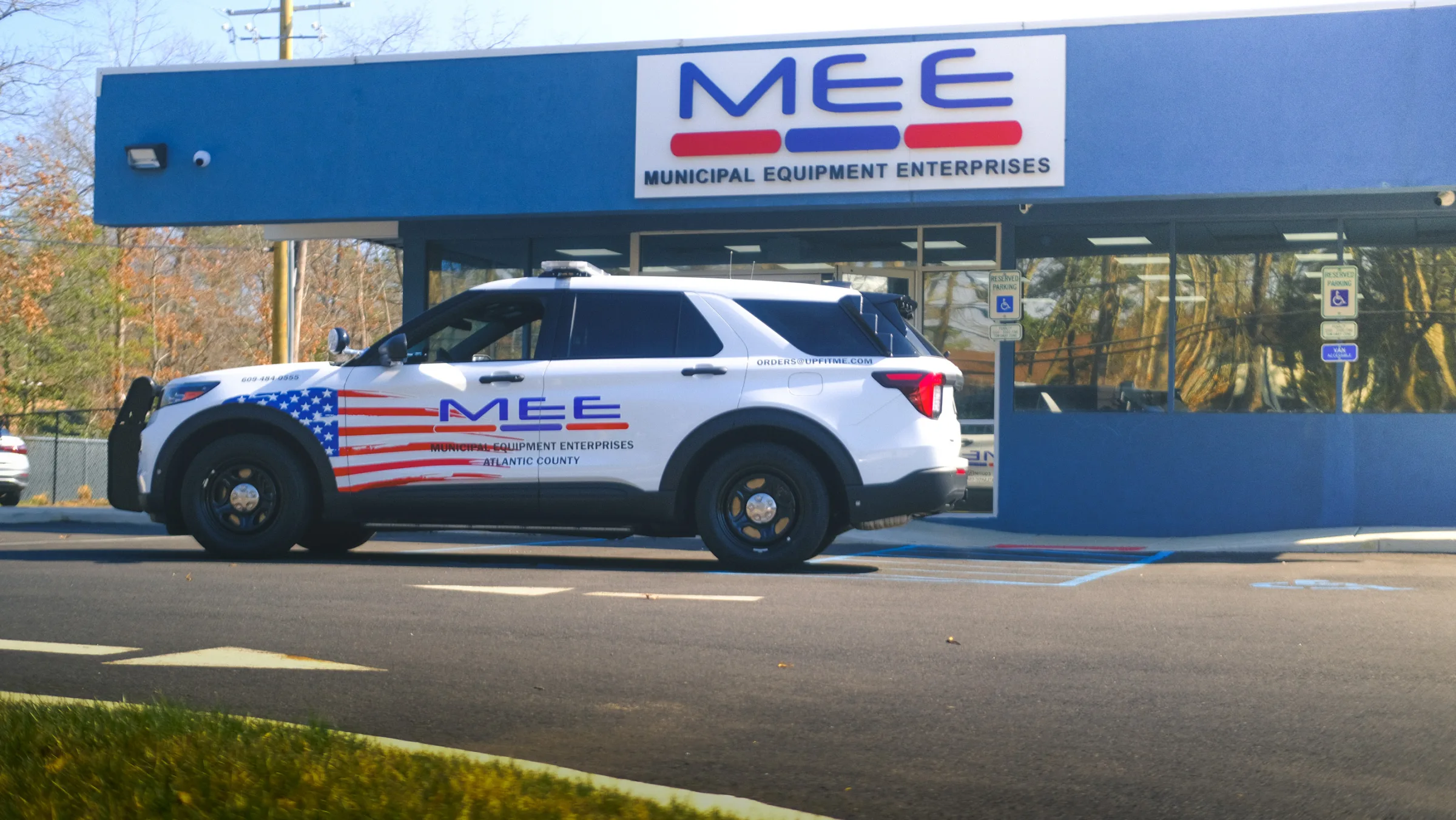 Side view of MEE’s marked SUV with vehicle graphics and roof light bar